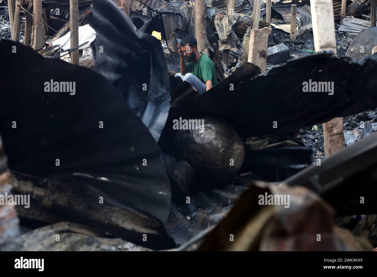 Dacca, Dacca, Bangladesh. 19 febbraio 2024. Un incendio è scoppiato oggi a mezzogiorno nel quartiere Jhilpar di Mirpur, Dacca. Circa 200 case di latta furono completamente bruciate. 8 unità di vigili del fuoco hanno portato l'incendio sotto controllo in un'ora. Gli abitanti delle baraccopoli cercano di trovare i loro ultimi effetti personali dalle baraccopoli bruciate. (Immagine di credito: © Syed Mahabubul Kader/ZUMA Press Wire) SOLO PER USO EDITORIALE! Non per USO commerciale! Crediti: ZUMA Press, Inc./Alamy Live News Foto Stock