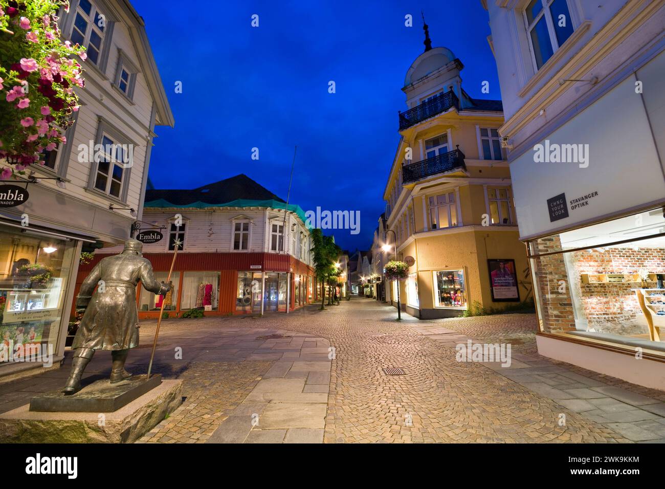 Vista notturna della strada di Stavanger, Norvegia. Statua dell'Old Time Watchman sulla sinistra Foto Stock