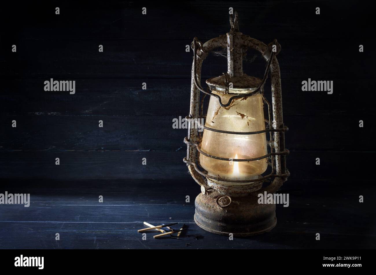 La lanterna Rusty kerosene brilla di luce al buio, tecnologia obsoleta nei tempi delle moderne lampade a risparmio energetico, concetto di tradizione, Hop Foto Stock