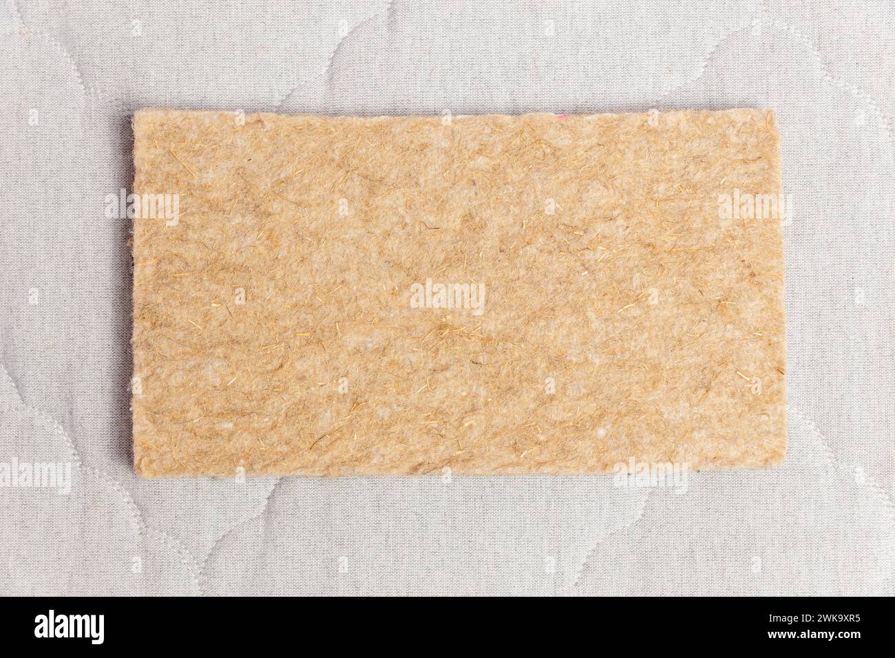 Un campione rettangolare di feltro termopressato utilizzato nella produzione di materassi moderni con blocchi a molla indipendenti. Vista dall'alto. Foto Stock