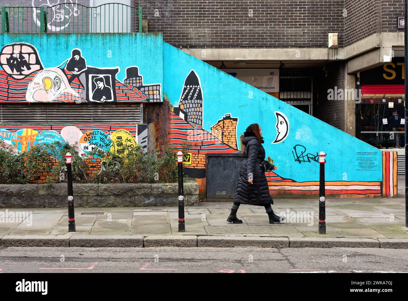 Una giovane donna adulta che cammina per la colorata Street art in Middlesex Street Aldgate City di Londra Inghilterra Regno Unito Foto Stock