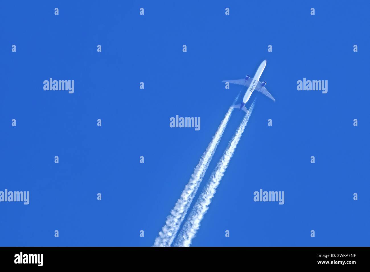 Volo bimotore jet di linea / aereo / aereo della compagnia aerea Kuwait Airways che mostra contrafforti / tracce di condensa contro il cielo blu Foto Stock