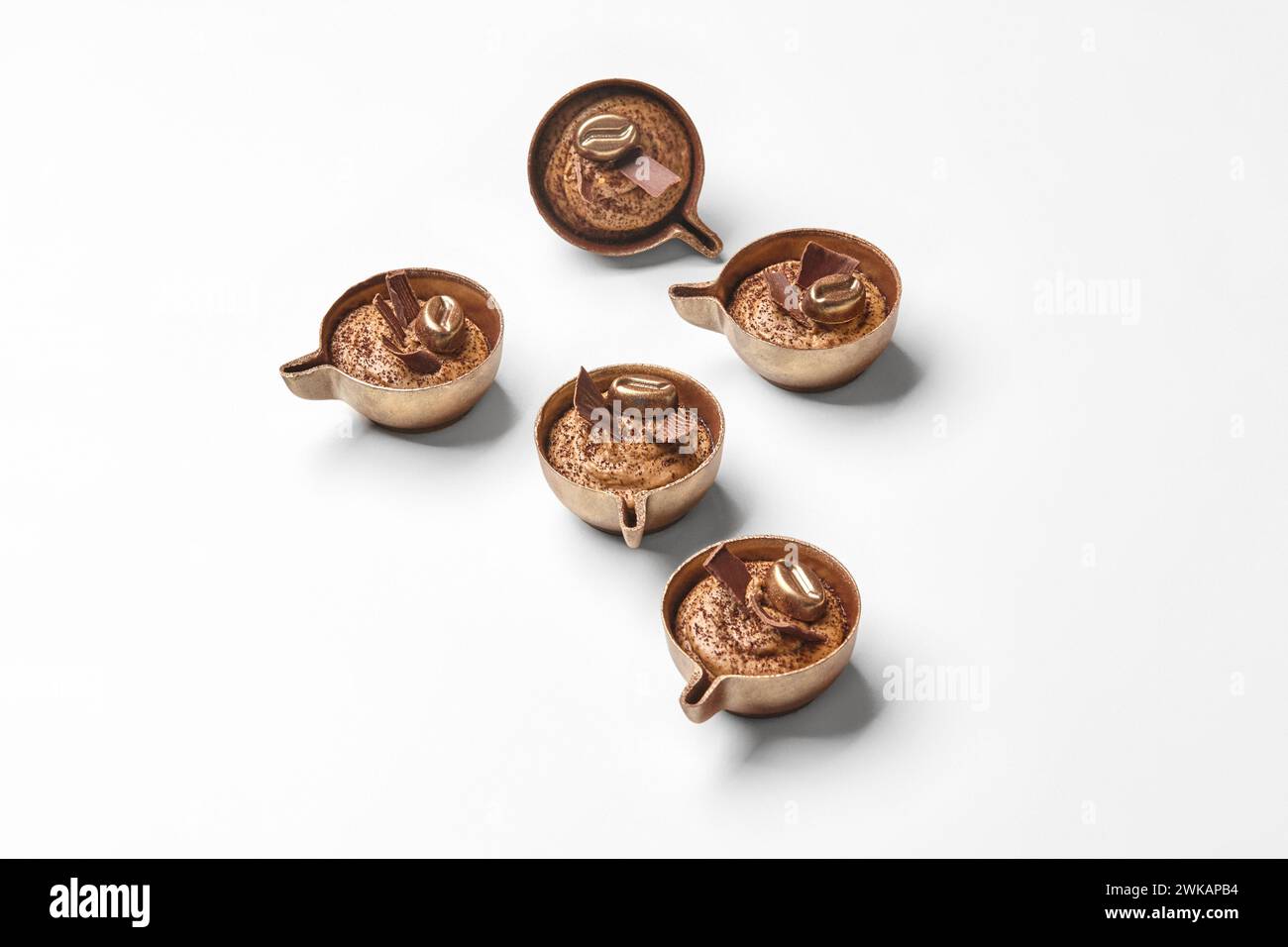 Caramelle al cioccolato a forma di tazze da caffè in miniatura su bianco Foto Stock