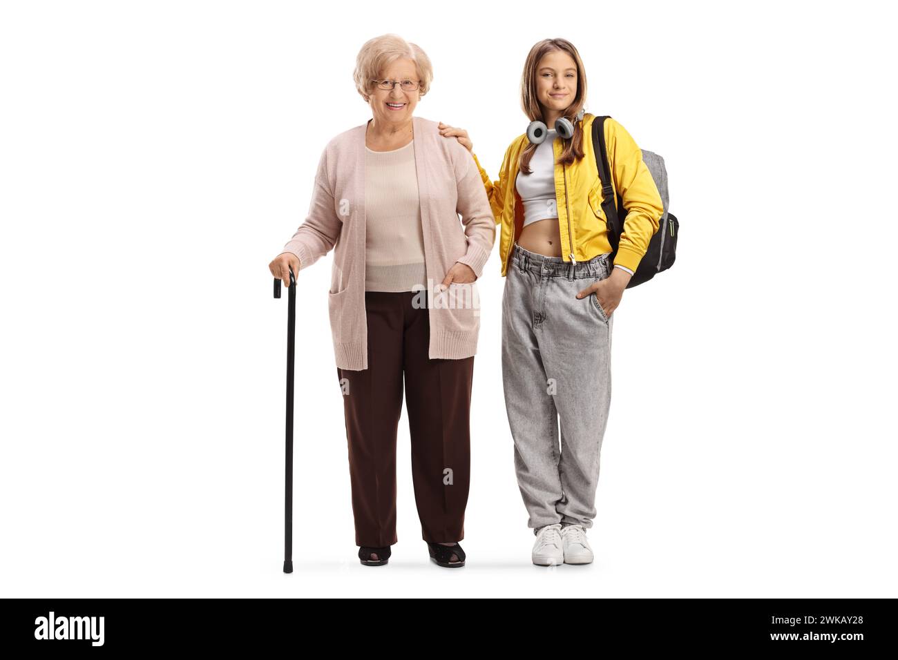 Adolescente alla moda che posa accanto a sua nonna isolata su sfondo bianco Foto Stock