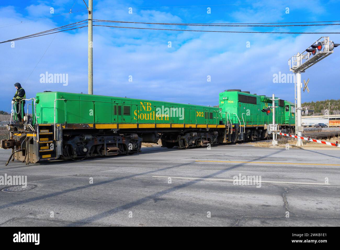 Saint John, NB, Canada - 2024-01-03: Un treno della NB Southern attraversa una strada cittadina. Il treno è composto solo da due locomotive, una a grandezza naturale e una più piccola a distanza. Foto Stock