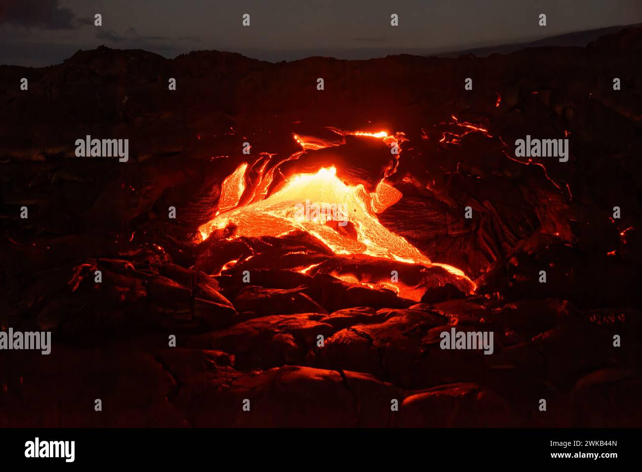 Flusso di lava attivo alle Hawaii, il magma sta uscendo da una fessura, lentamente raffreddandosi e solidificandosi in vari schemi, bagliore della lava Foto Stock