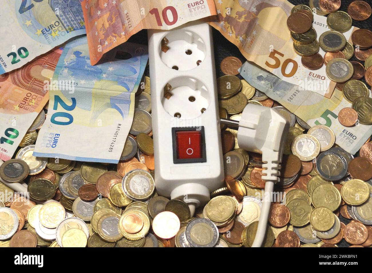 presa di corrente e denaro, immagine simbolica dei costi dell'elettricità Foto Stock