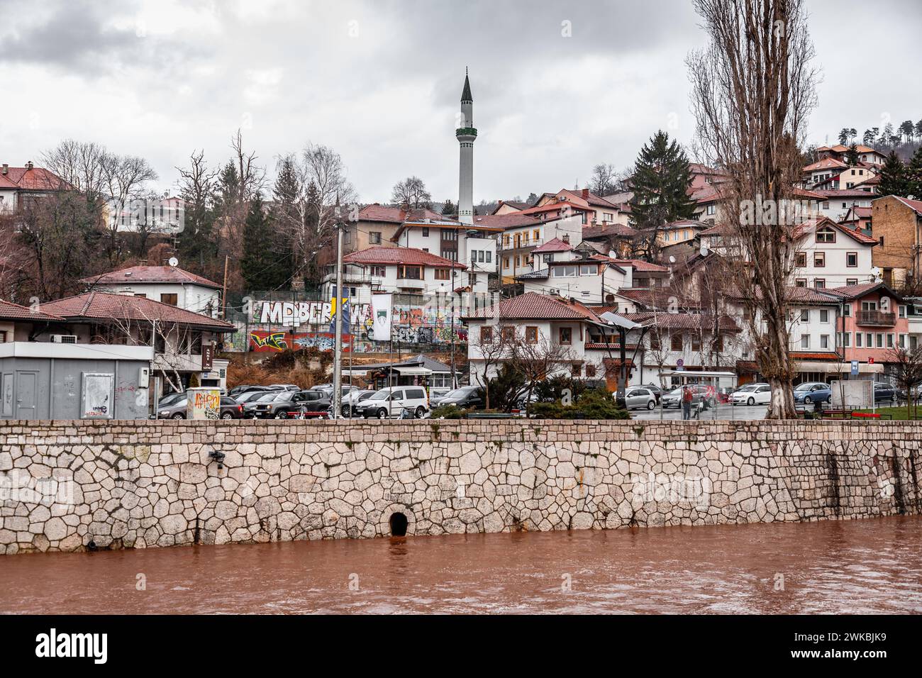 Sarajevo - Bosnia ed Erzegovina - 11 febbraio 2024: Tipica architettura bosniaca e vista del paesaggio urbano sul lato del fiume Miljacka. Foto Stock