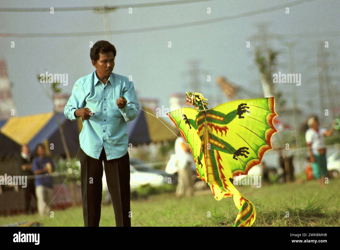 Un partecipante prepara un aquilone durante il Jakarta International Kite Festival 2004 che si è tenuto il 9-11 luglio presso Carnival Beach ad Ancol Dreamland, Ancol, Penjaringan, Giacarta Nord, Giacarta, Indonesia. Foto Stock