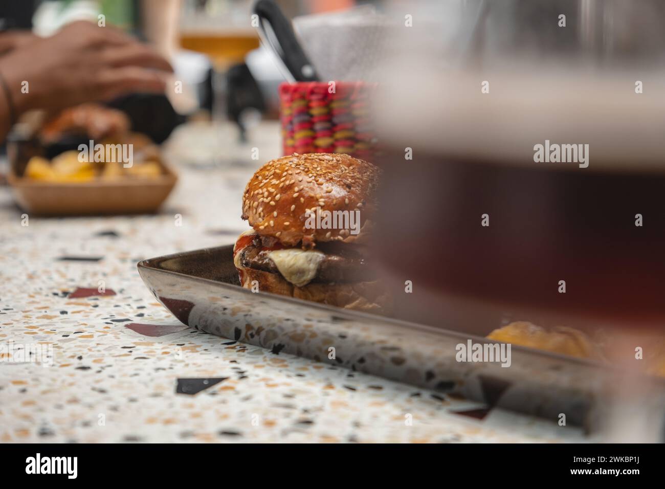 Delizioso cibo da pub. Hamburger e bicchieri di birra su piatti di legno Foto Stock