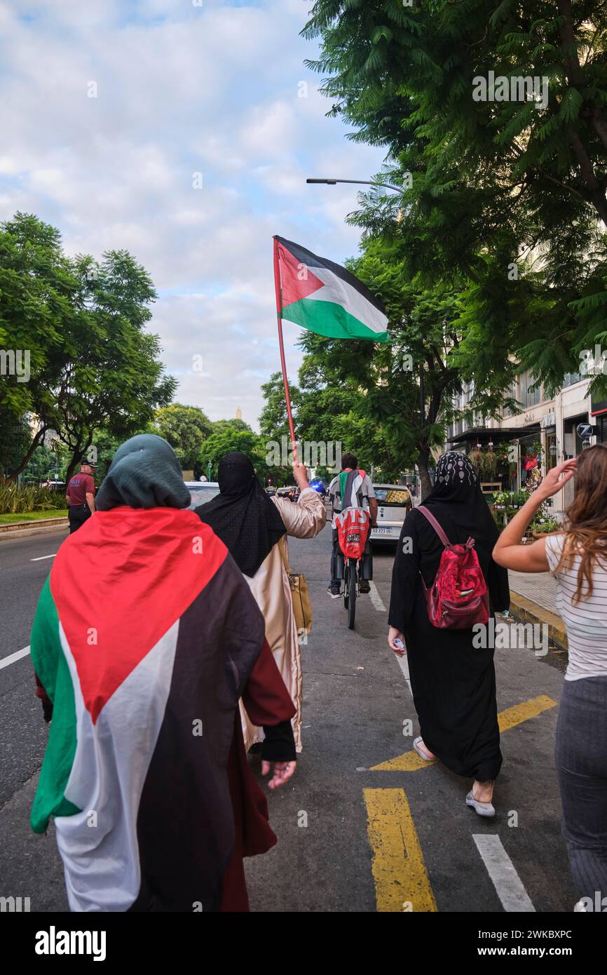 Buenos Aires, Argentina, 16 febbraio 2024: Persone che marciano con bandiere palestinesi in solidarietà con la Palestina contro l'attacco di genocidio israeliano. Foto Stock