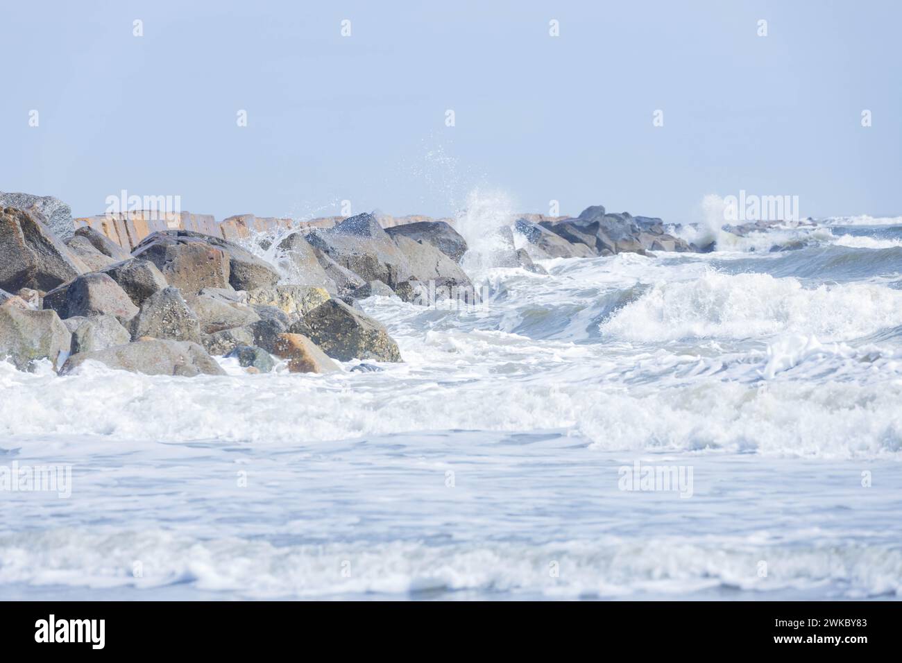 Onde che si infrangono sulle rocce sulla spiaggia Foto Stock