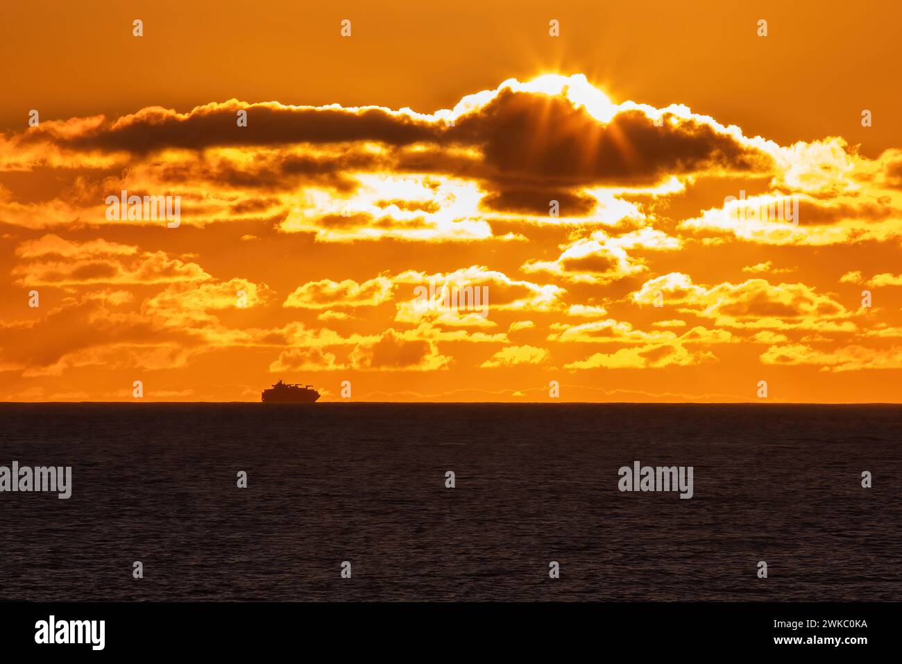 Nave merci che aggira il Capo di buona speranza al largo delle coste del Sudafrica al tramonto. Foto Stock