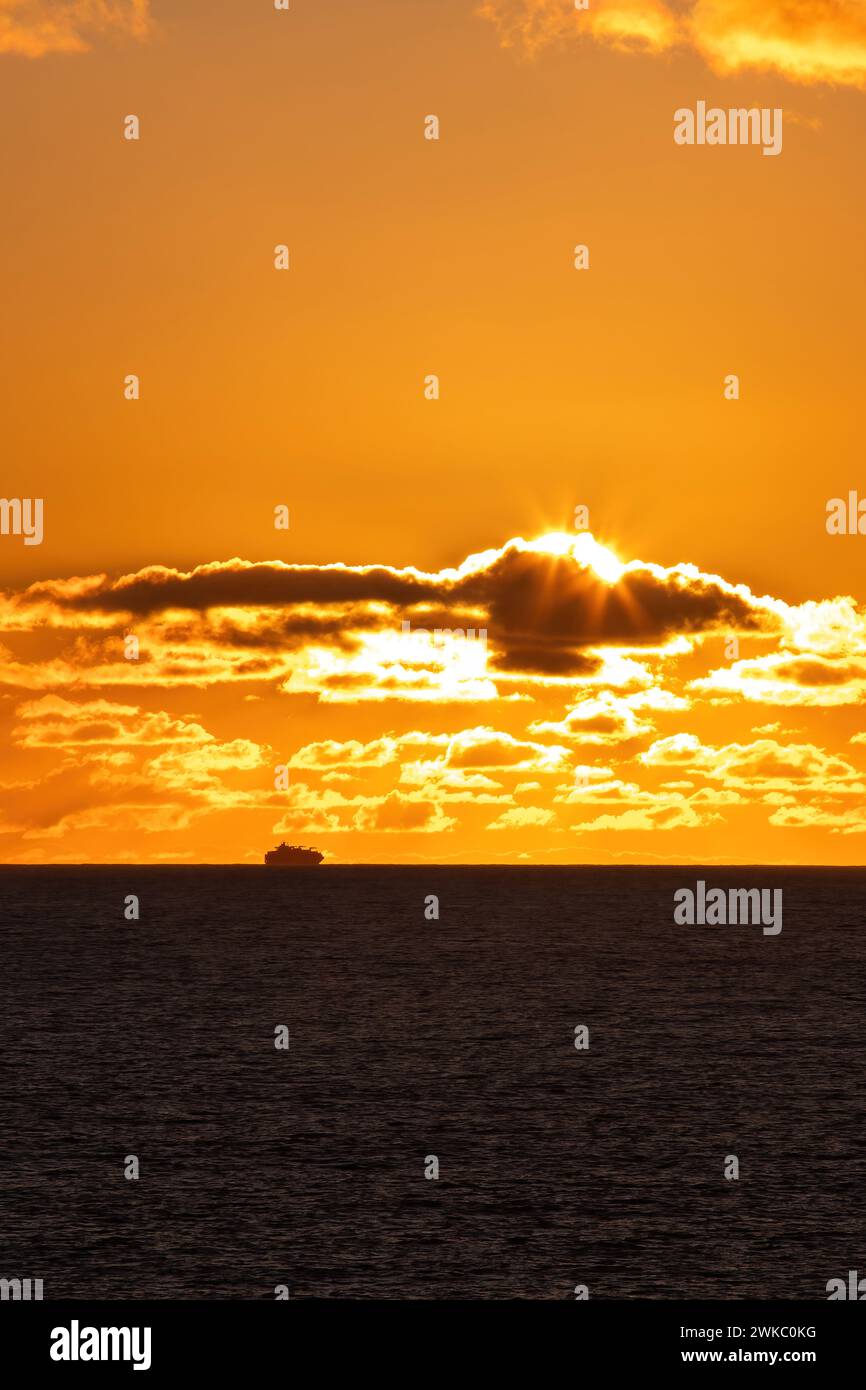 Nave merci che aggira il Capo di buona speranza al largo delle coste del Sudafrica al tramonto. Foto Stock