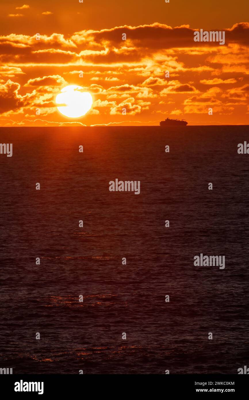 Nave merci che aggira il Capo di buona speranza al largo delle coste del Sudafrica al tramonto. Foto Stock