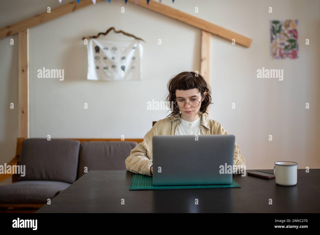 Si è concentrata sullo studio online di una studentessa seduta alla scrivania con un notebook che guardava il webinar di formazione. Foto Stock