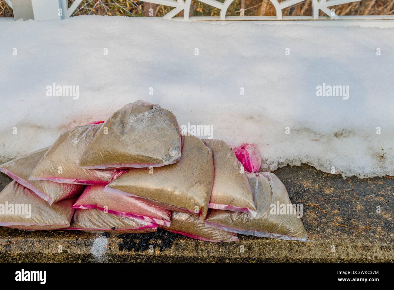 Piccoli sacchi di sabbia sul marciapiede accanto alla sponda di neve fresca della Corea del Sud Foto Stock
