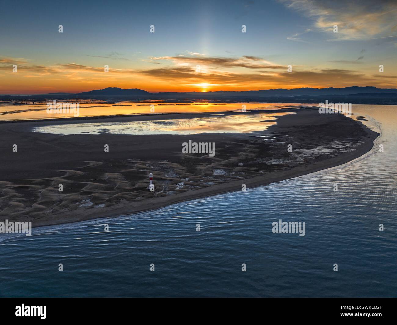 Vista aerea di Punta del Fangar e del suo faro su un tramonto invernale rosso nel Delta dell'Ebro (Tarragona, Catalogna, Spagna) Foto Stock