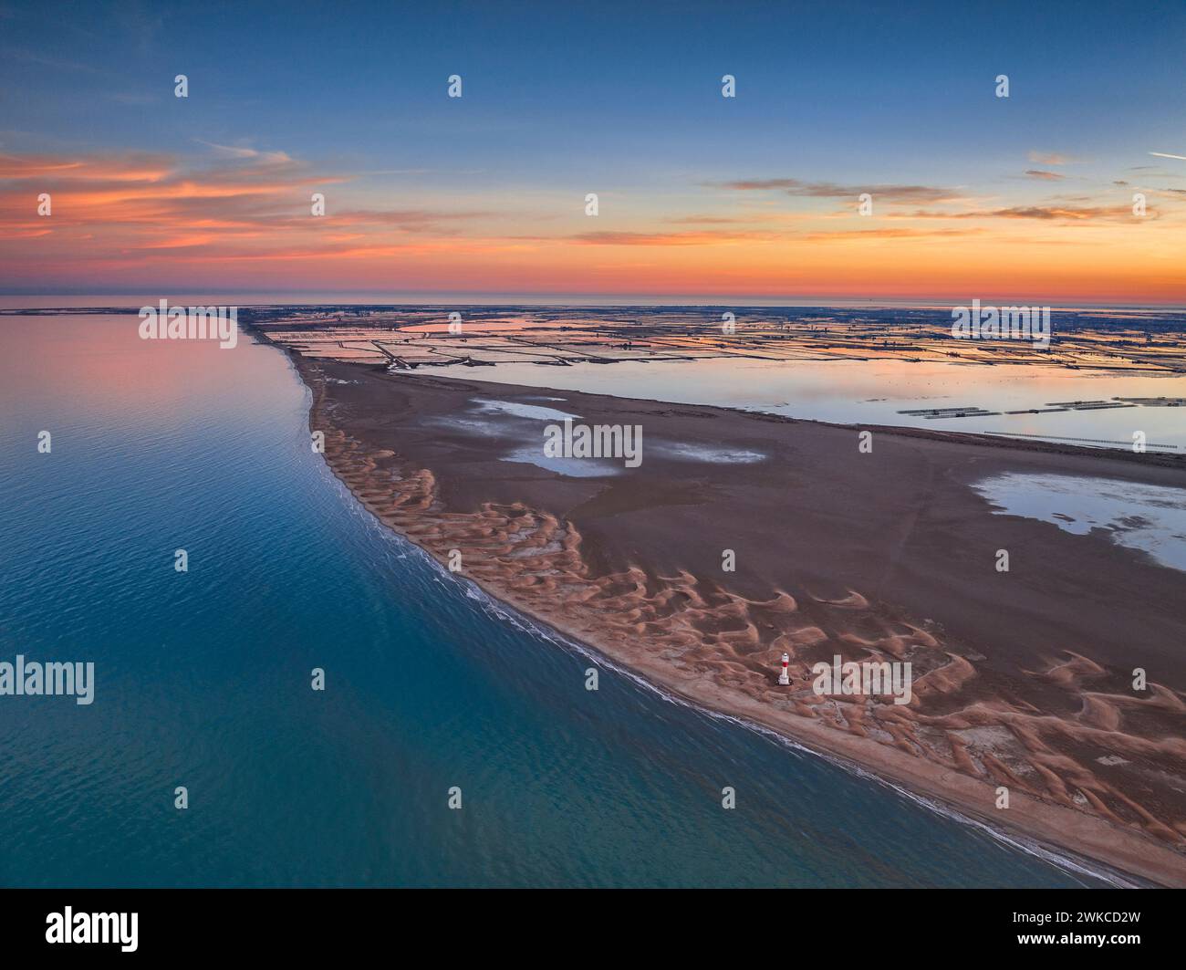 Vista aerea di Punta del Fangar e del suo faro su un tramonto invernale rosso nel Delta dell'Ebro (Tarragona, Catalogna, Spagna) Foto Stock