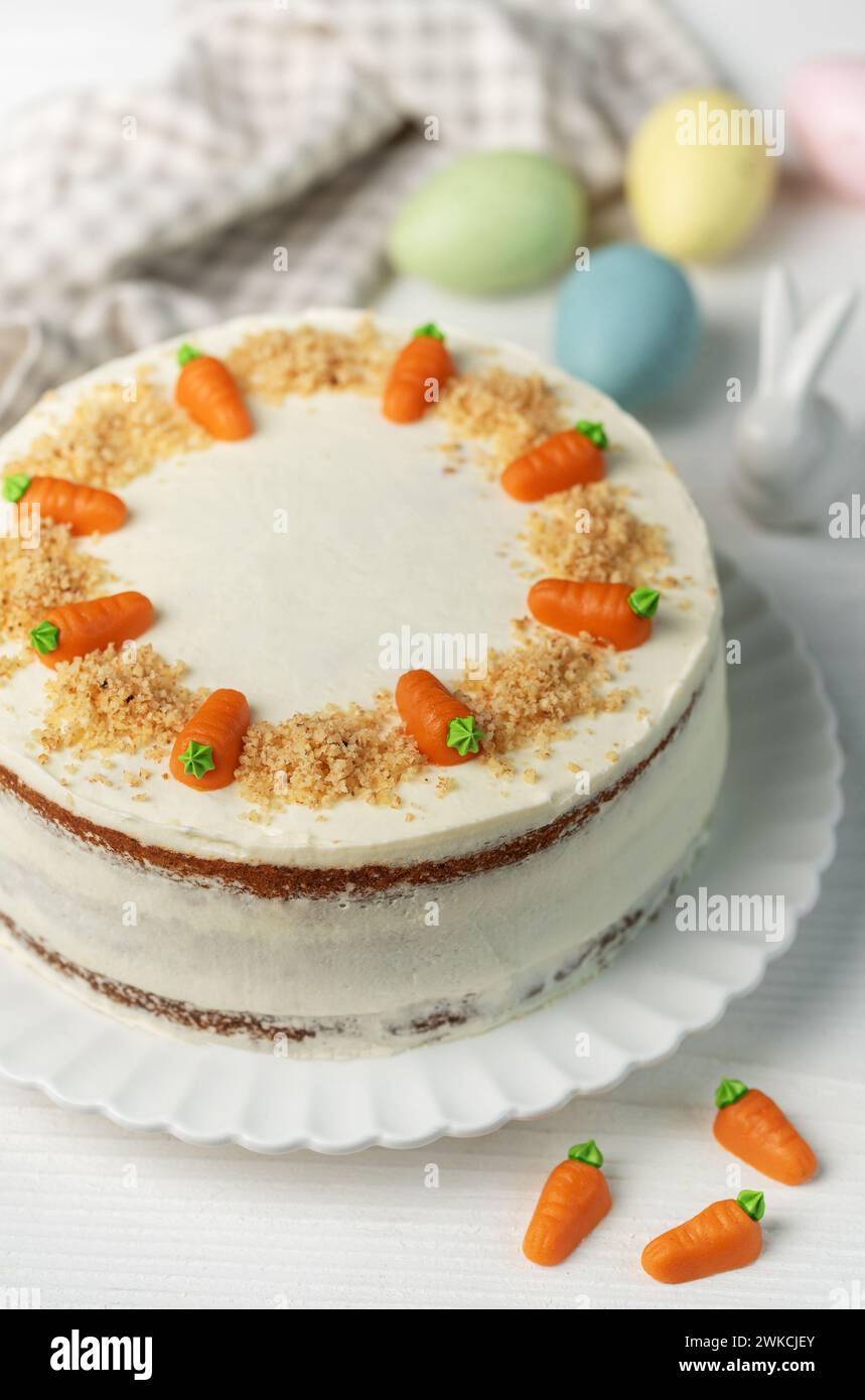 Torta di carote pasquali fatta in casa con noci, ghiacciata con formaggio spalmabile. Dolce dolce. Piatto con deliziosa torta di carote Foto Stock