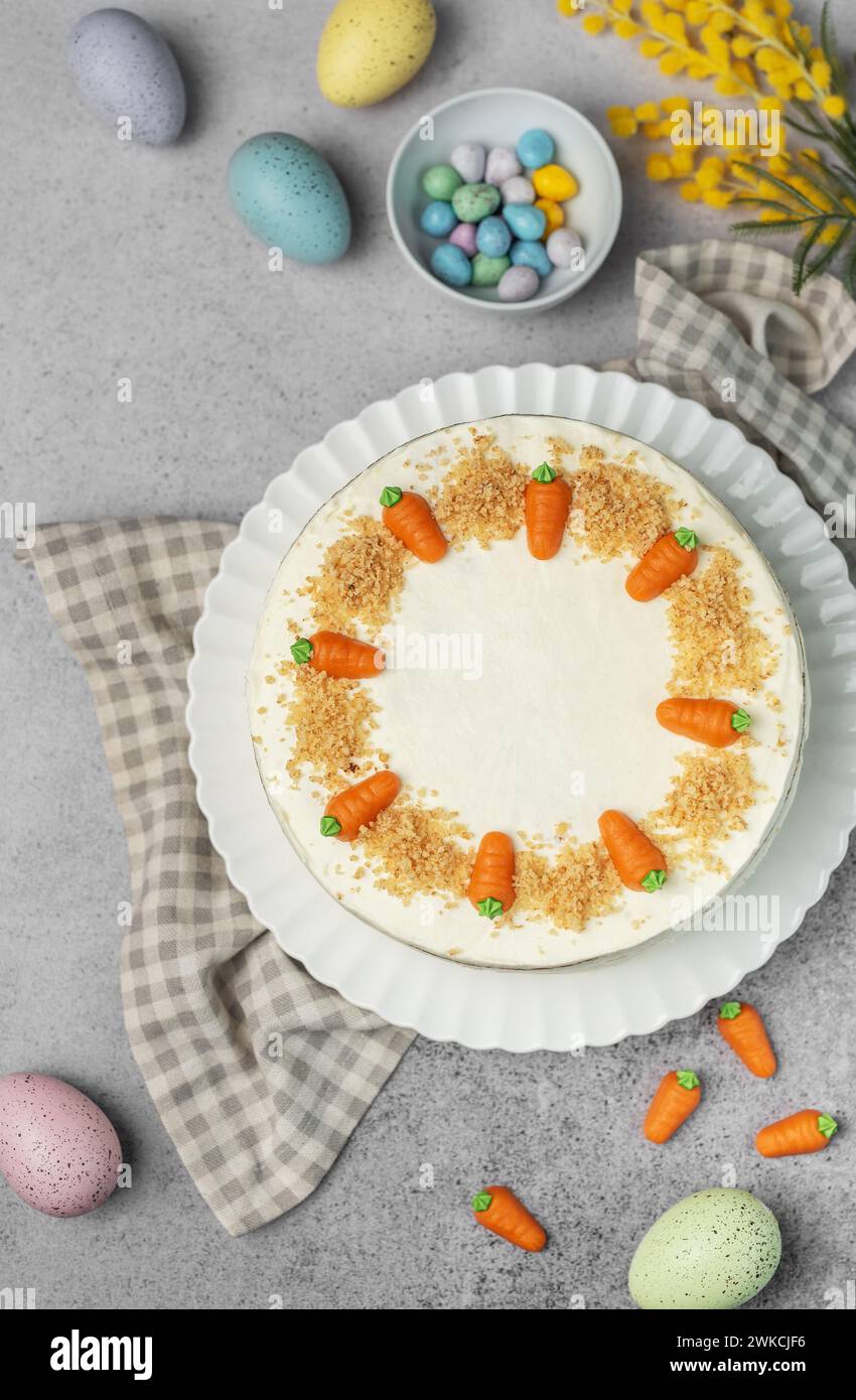 Torta di carote pasquali fatta in casa con noci, ghiacciata con formaggio spalmabile. Dolce dolce. Piatto con deliziosa torta di carote Foto Stock