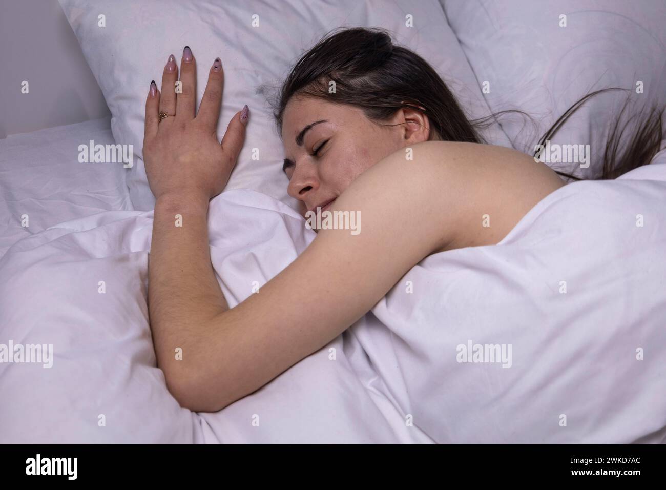 La ragazza dorme in un letto bianco. Foto Stock