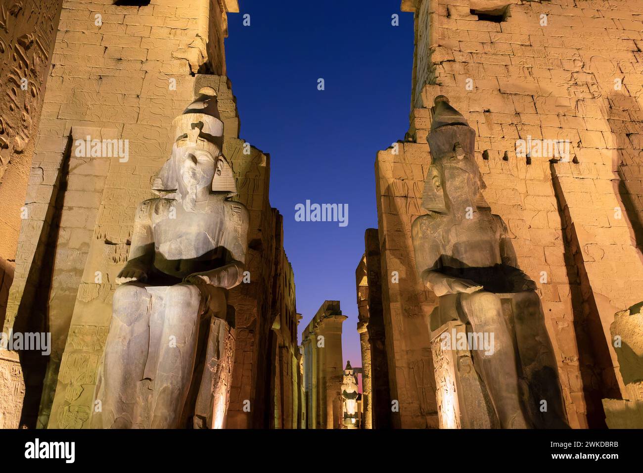 Statue colossali di Ramses II (Ramses II) nel tempio di Luxor illuminato di notte, a Luxor, Egitto Foto Stock