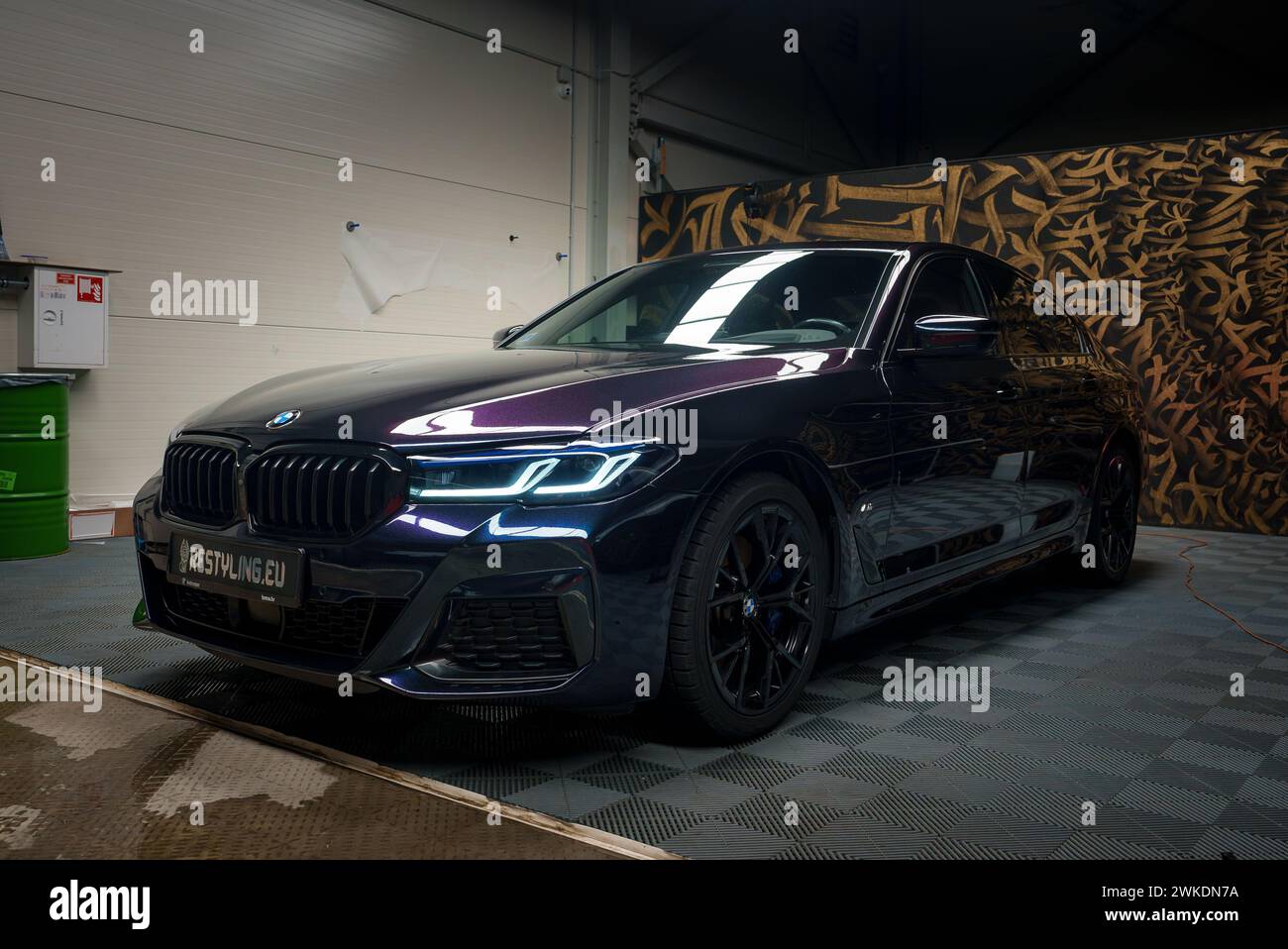 Elegante BMW nera con fari a LED illuminati in un garage di sintonizzazione Foto Stock