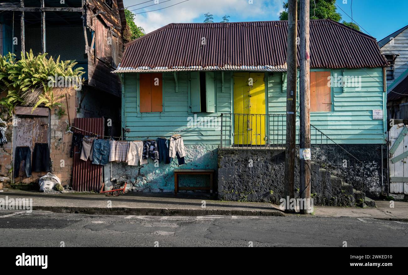 Una casa in legno con esterni colorati e vestiti appesi a dominica Foto Stock
