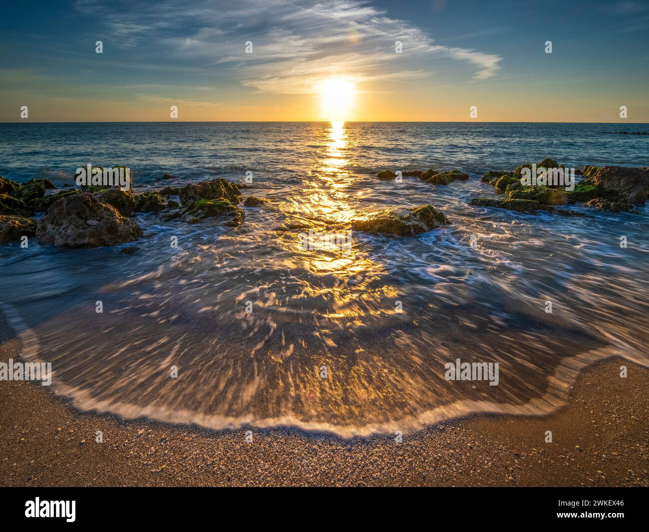 Piccole onde si riversano sulla spiaggia rocciosa del Golfo del Messico a Caspersen Beach al tramonto a Venice, Florida, USA Foto Stock