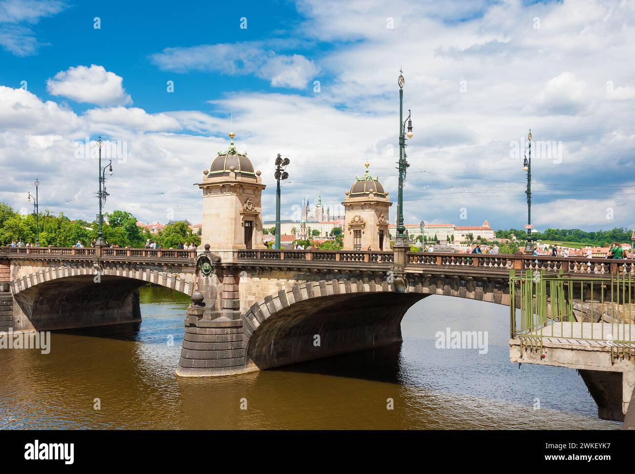 La gente cammina attraverso il bellissimo Ponte della Legione con il Castello di Praga sullo sfondo Foto Stock