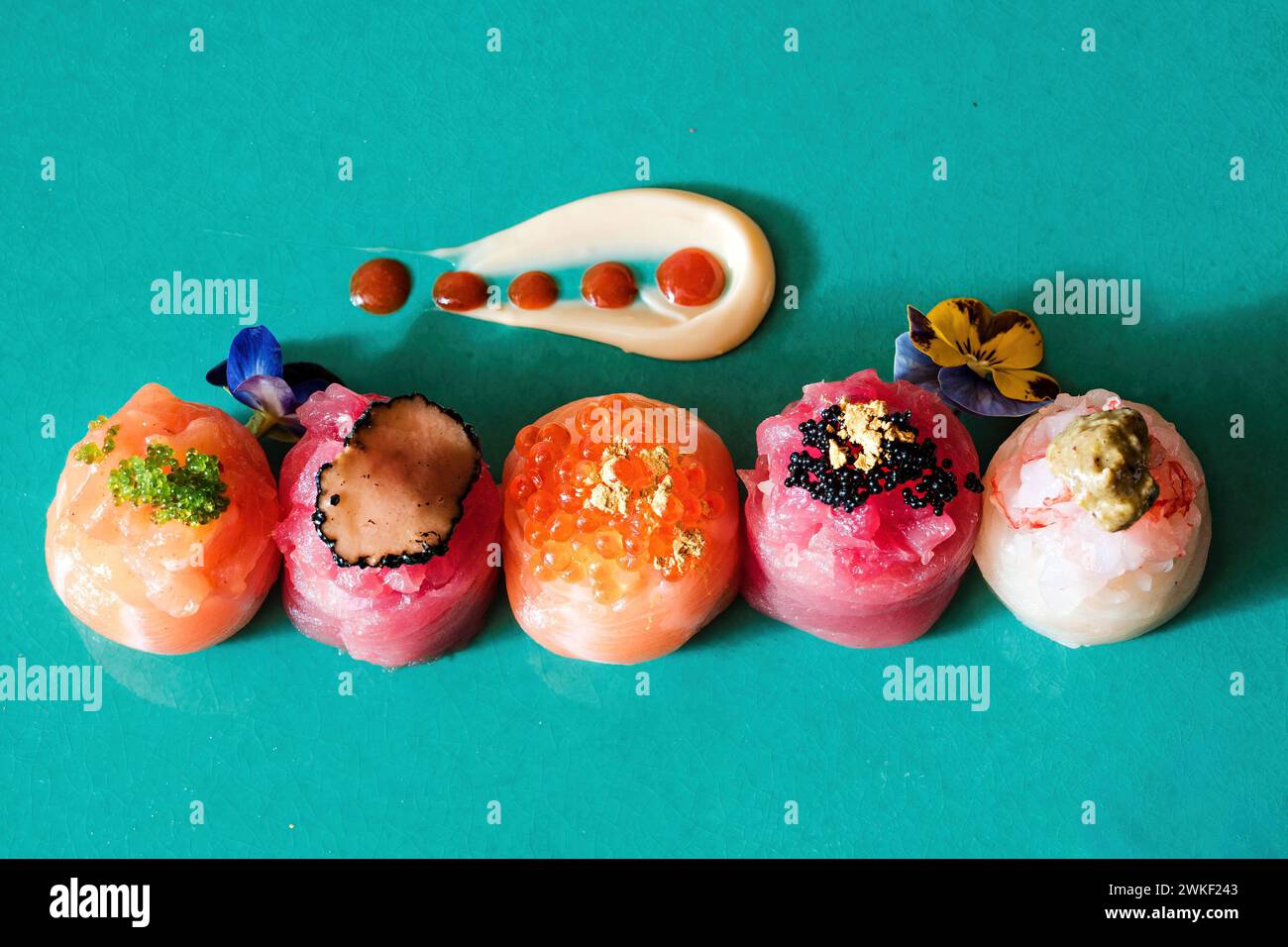 Mostra artistica di sushi temari con vari condimenti - un tocco moderno di cucina tradizionale giapponese Foto Stock
