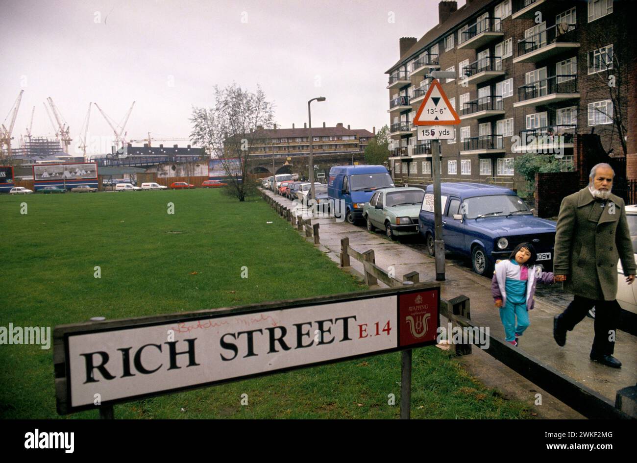 Rich Street contrasta la parte est di Londra degli anni '1980 del Regno Unito. Povertà urbana padre e figlio asiatici. Limehouse, Londra, Inghilterra settembre 1989. HOMER SYKES Foto Stock