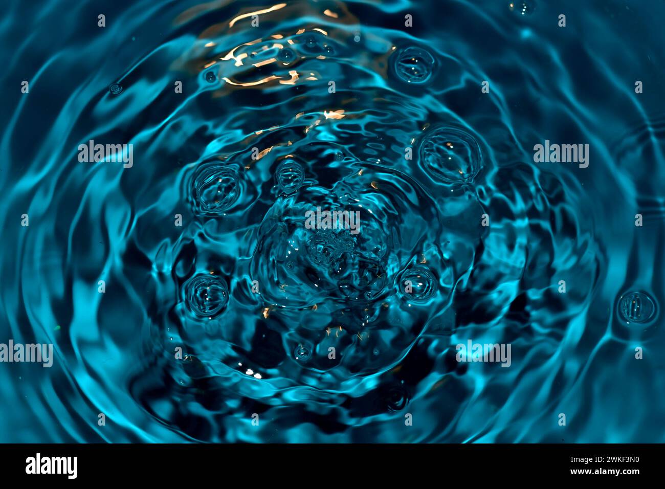 Superficie dell'acqua senza riposo dopo la caduta di gocce. Foto Stock