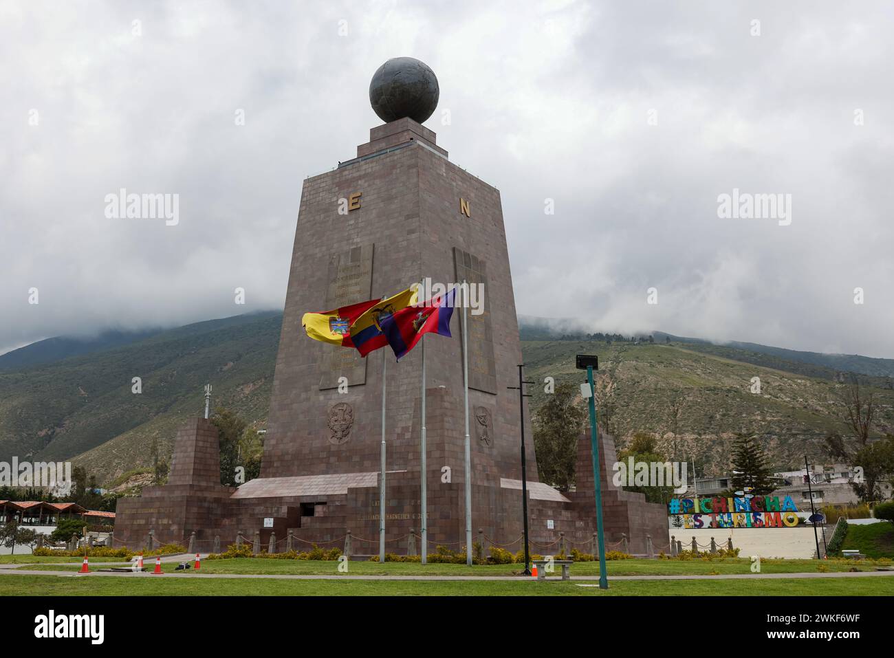 Quito, Ecuador - 22 marzo 2023: Monumento all'equatore nel parco Mitad del Mundo, appena a nord di Quito con la bandiera nazionale Foto Stock