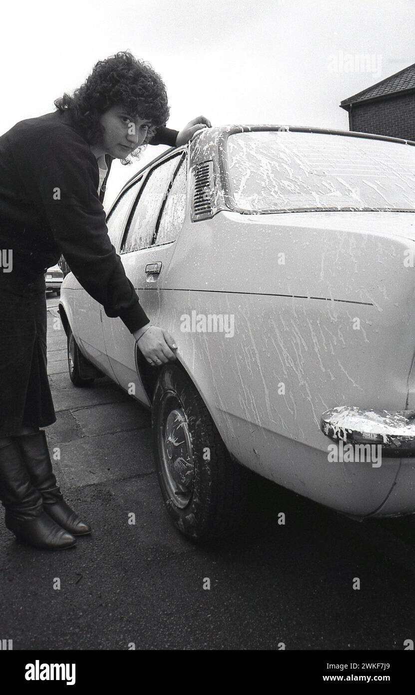 Anni '1980, storica signora che mostra un liquido di copertura sul retro della sua auto, Inghilterra, Regno Unito. Foto Stock Anni '1980, storica signora che mostra un liquido di copertura sul retro della sua auto, Inghilterra, Regno Unito. Foto Stock