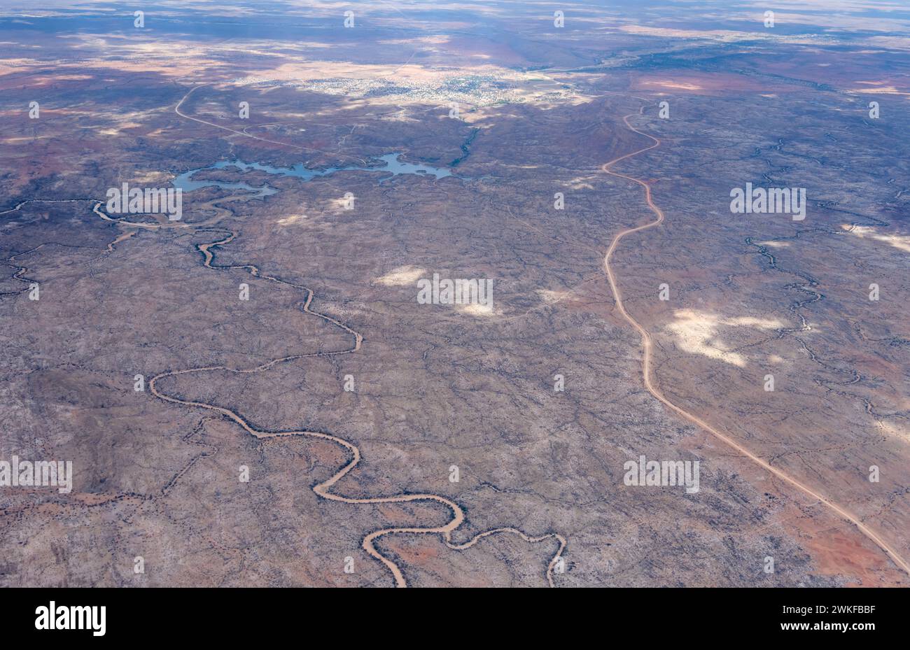 Atterraggio aereo con letti di fiume asciutti e lago Oanob nel deserto, girato da un aereo aliante con la luce brillante della tarda primavera da ovest, Namibia, Africa Foto Stock