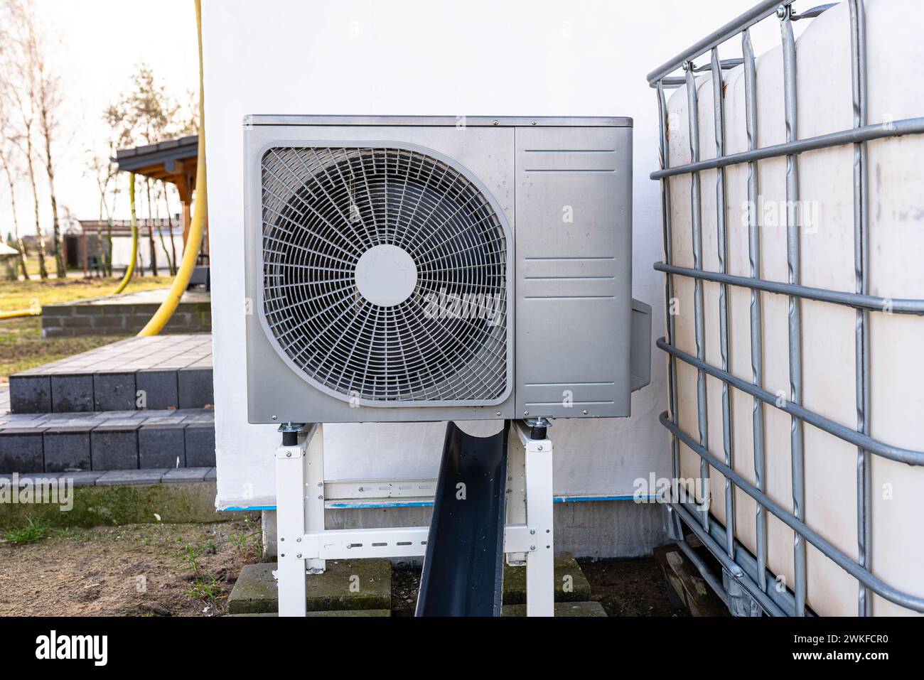 Unità esterna di una pompa di calore dell'aria a bassa potenza situata di fronte all'abitazione. Foto Stock