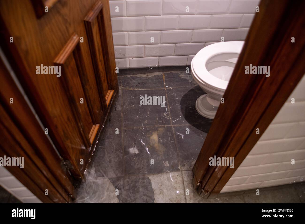 Chalfont St Peter, Regno Unito. 18 febbraio 2024. Le acque sotterranee del fiume Misbourne si sono inondate attraverso il pavimento e nei bagni del pub Greyhound Inn nel villaggio di Chalfont St Peter. Il pub è stato costretto a chiudere. La Thames Water è fuori dal pub che pompava acqua da un certo numero di settimane. L'inondazione è peggiorata di nuovo oggi dopo la pioggia notturna. Anche se l'area è già stata allagata, molti locali credono che la ragione dell'estesa inondazione questa volta si riferisca a HS2 che ha scavato sottoterra nella regione per la ferrovia ad alta velocità. Crediti: Maur Foto Stock