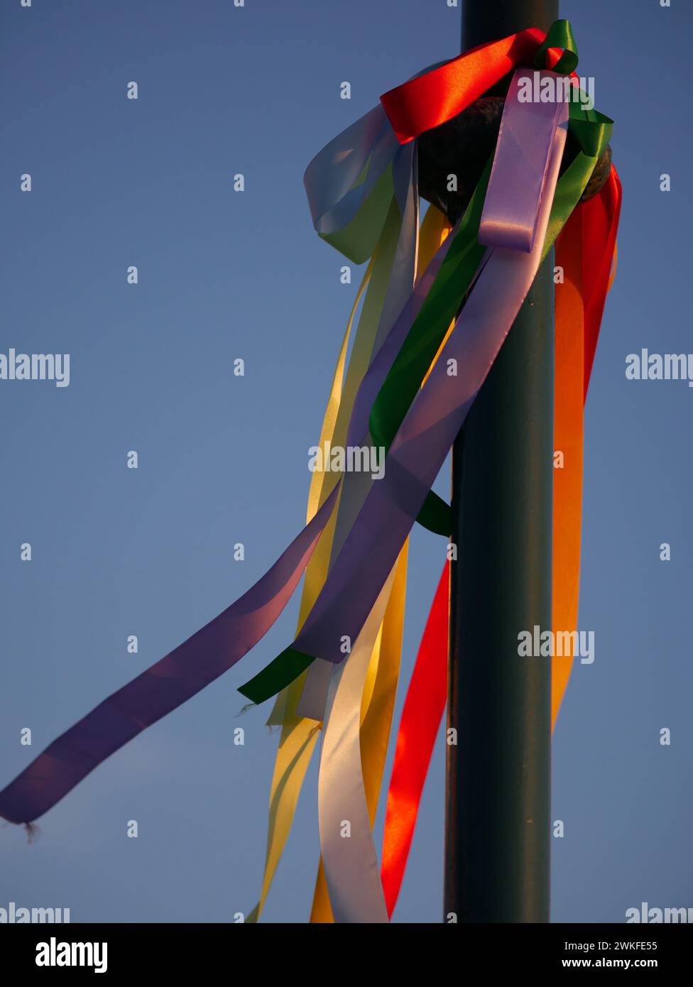 I nastri di seta colorati sfrecciano su un palo per l'illuminazione stradale sotto i raggi del sole al tramonto. San Valentino. Rovigno, Croazia - 13 febbraio 2024 Foto Stock