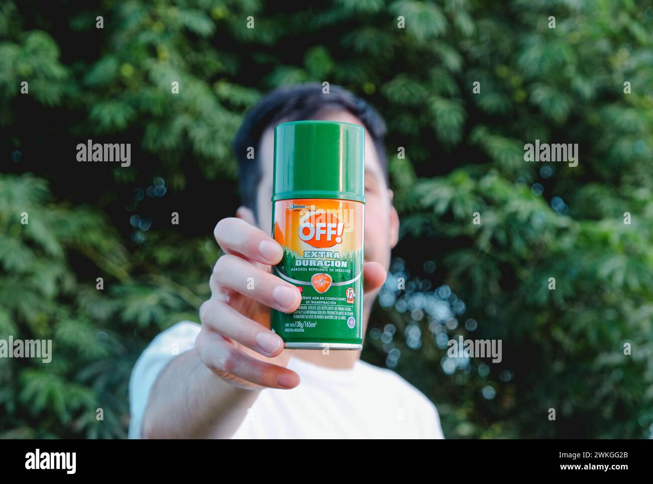 Giovane uomo con in mano Un repellente per zanzare. Sconvolgente invasione delle zanzare in Argentina. Misure di protezione per Dengue. Foto Stock