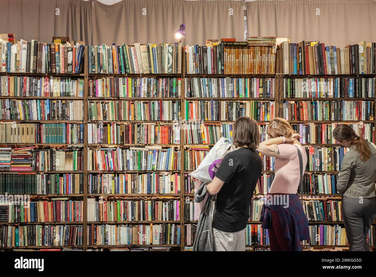 Foto di un gruppo di clienti, uomini e donne, che passano davanti agli scaffali di una libreria serba di Belgrado che vende libri di seconda mano di letteratura serba Foto Stock
