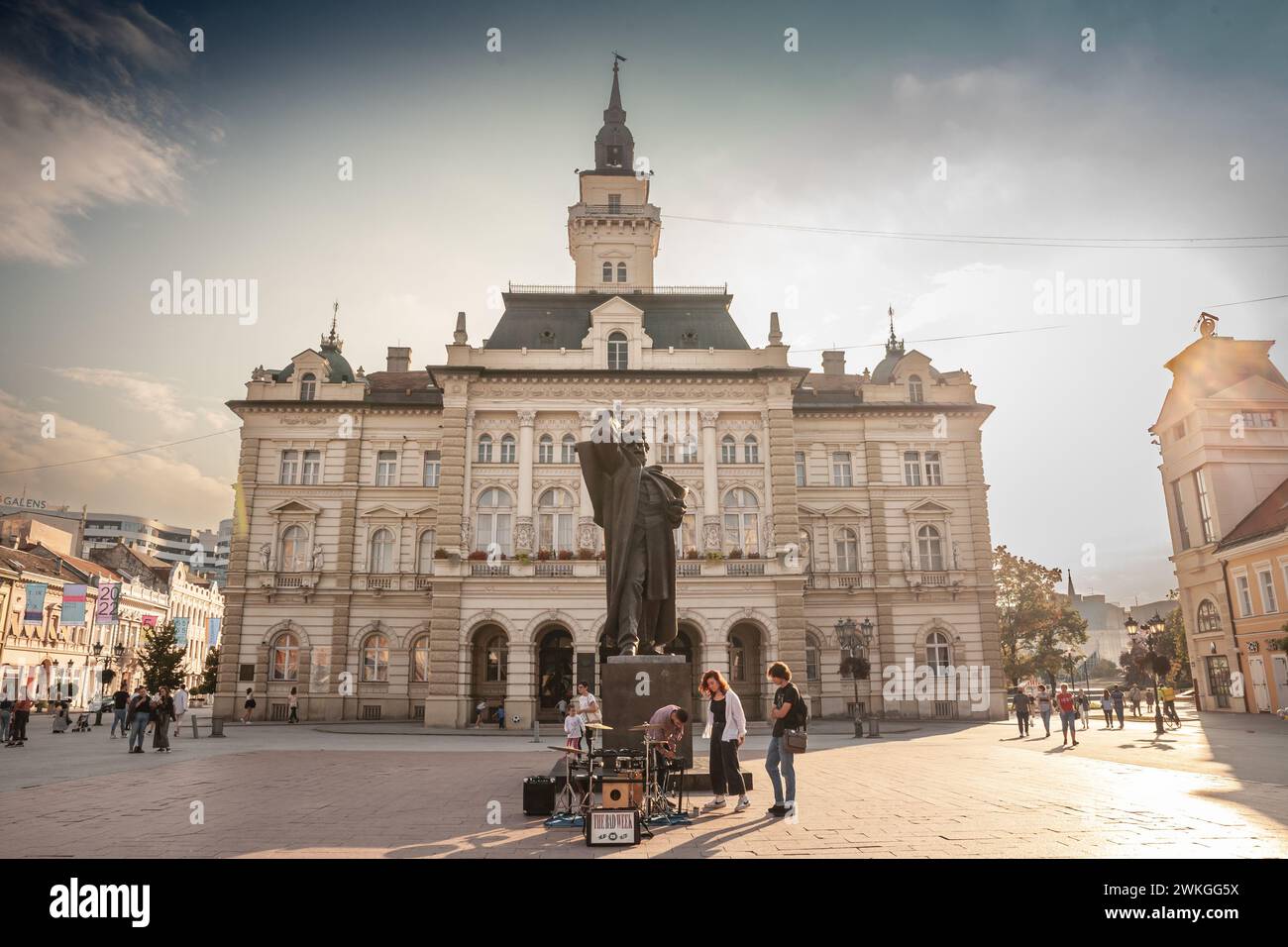 Foto della piazza centrale di Novi Sad, Serbia, chiamata Trg Slobode, con il municipio sullo sfondo e i pedoni che passano accanto e lo svetozar mi Foto Stock