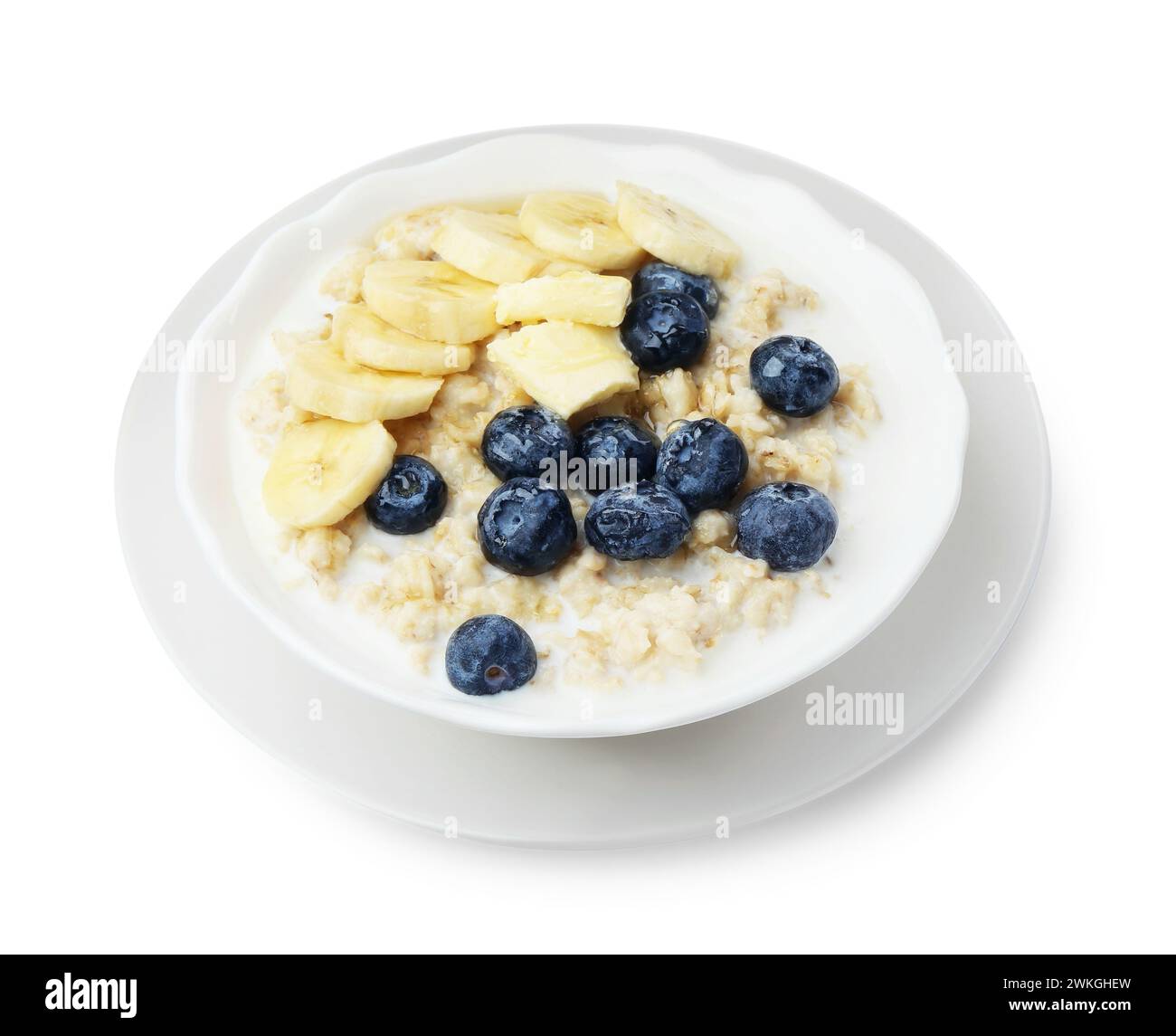 Gustosa farinata d'avena con banana, mirtilli, latte e burro nel recipiente isolato su bianco Foto Stock