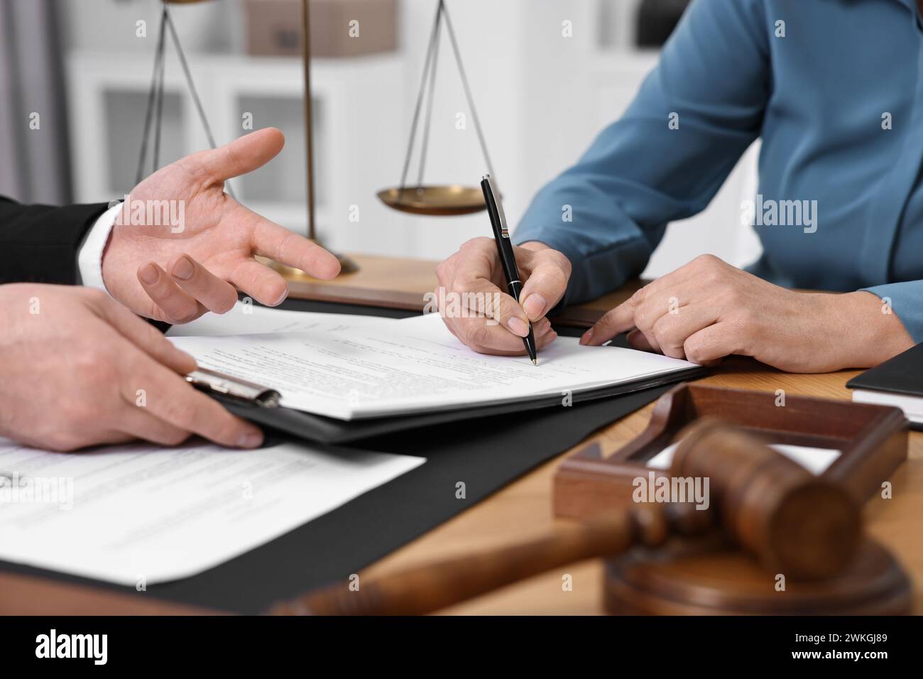 Donna anziana che firma un documento nell'ufficio dell'avvocato, primo piano Foto Stock