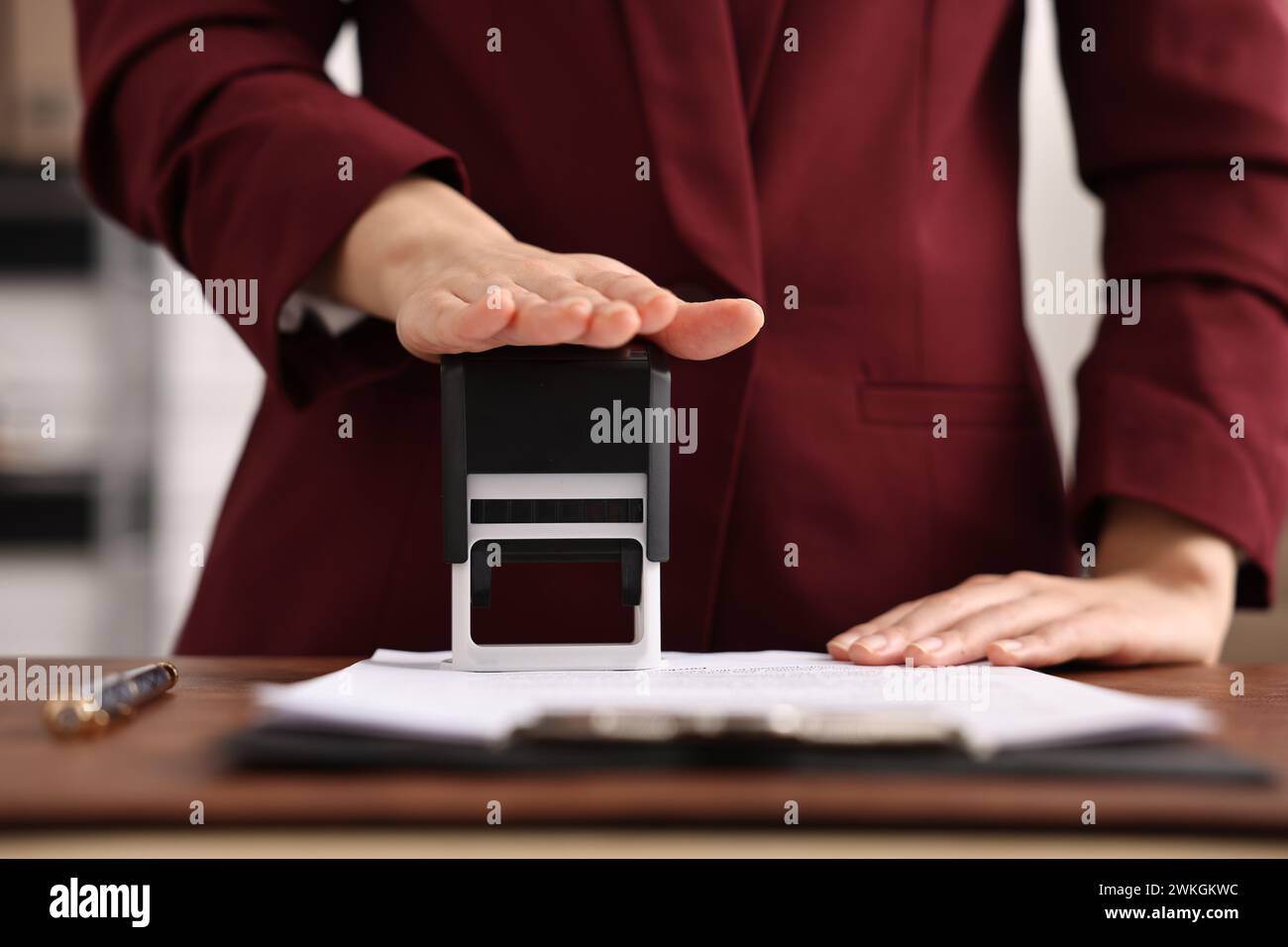 Documento di timbratura notaio a tavola in ufficio, primo piano Foto Stock