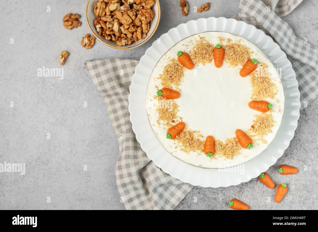 Torta di carote fatta in casa con noci, ghiacciata con formaggio spalmabile. Dolce dolce. Piatto con deliziosa torta di carote Foto Stock