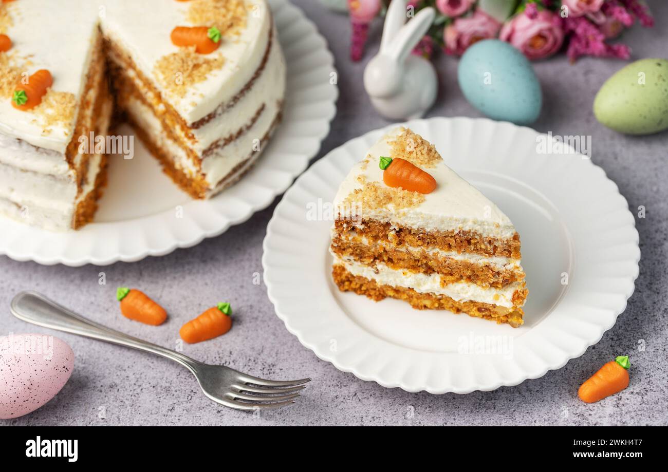 Torta di carote pasquali fatta in casa con noci, ghiacciata con formaggio spalmabile. Dolce dolce. Piatto con deliziosa torta di carote Foto Stock