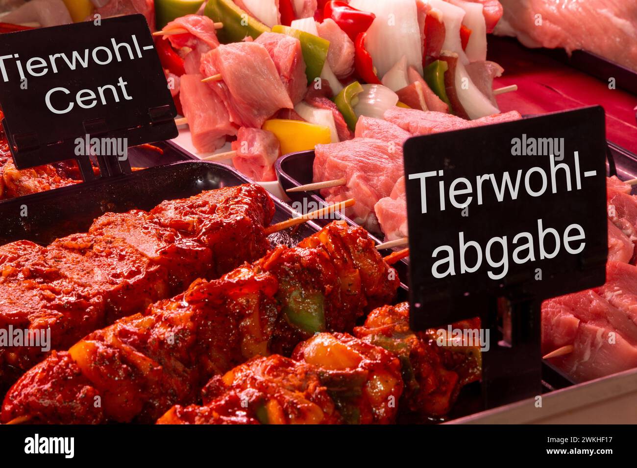 Febbraio 2024: Banco carni in macelleria con cartelli TIERWOHLCENT (centro benessere degli animali) e TIERWOHLABGABE (tassa sul benessere degli animali), Compos Foto Stock