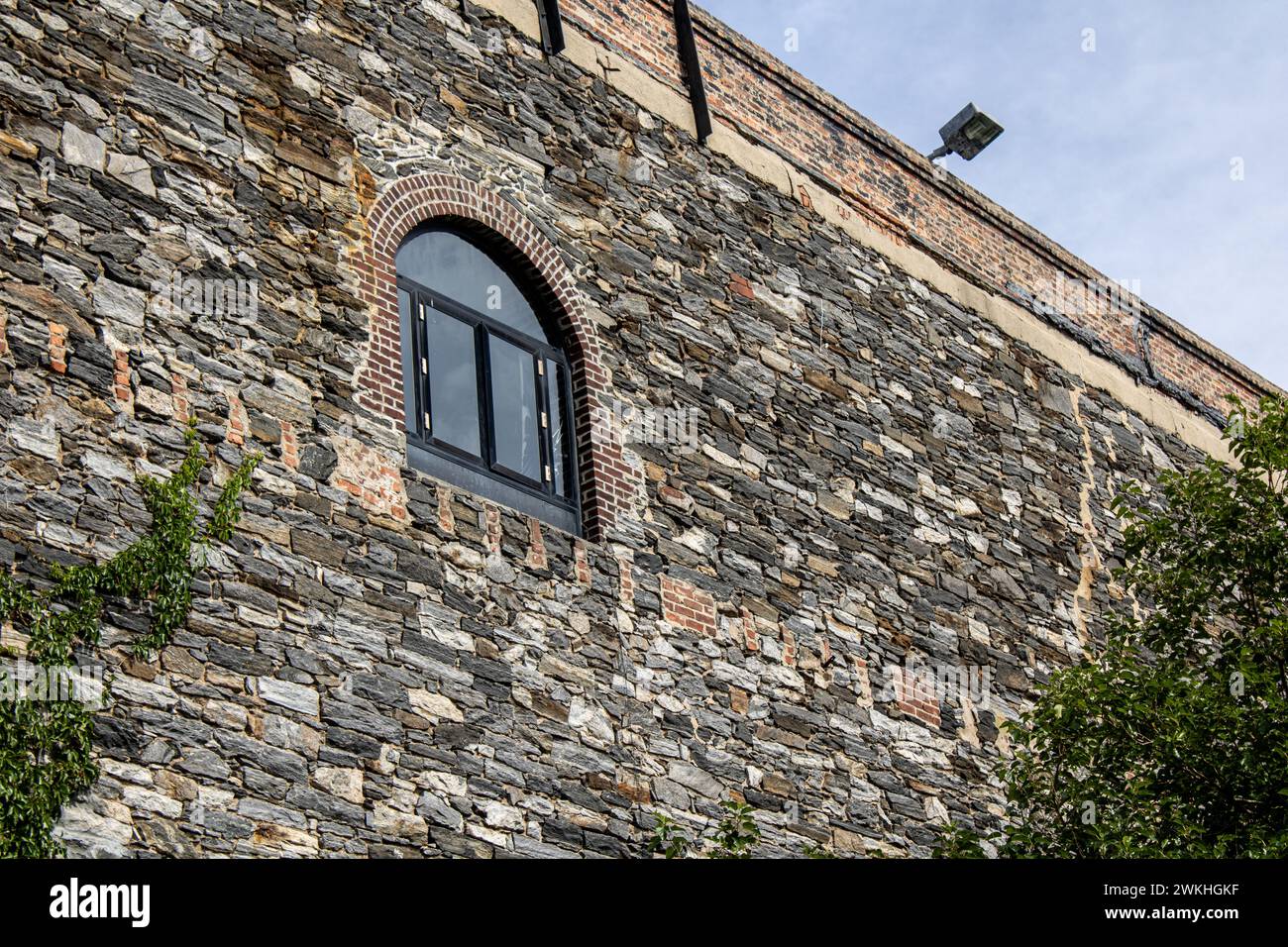 Cortile rustico con viti e ganci rossi su una vecchia casa Foto Stock